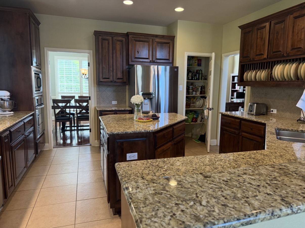 Dated kitchen with dark wood cabinets and granite before the remodel