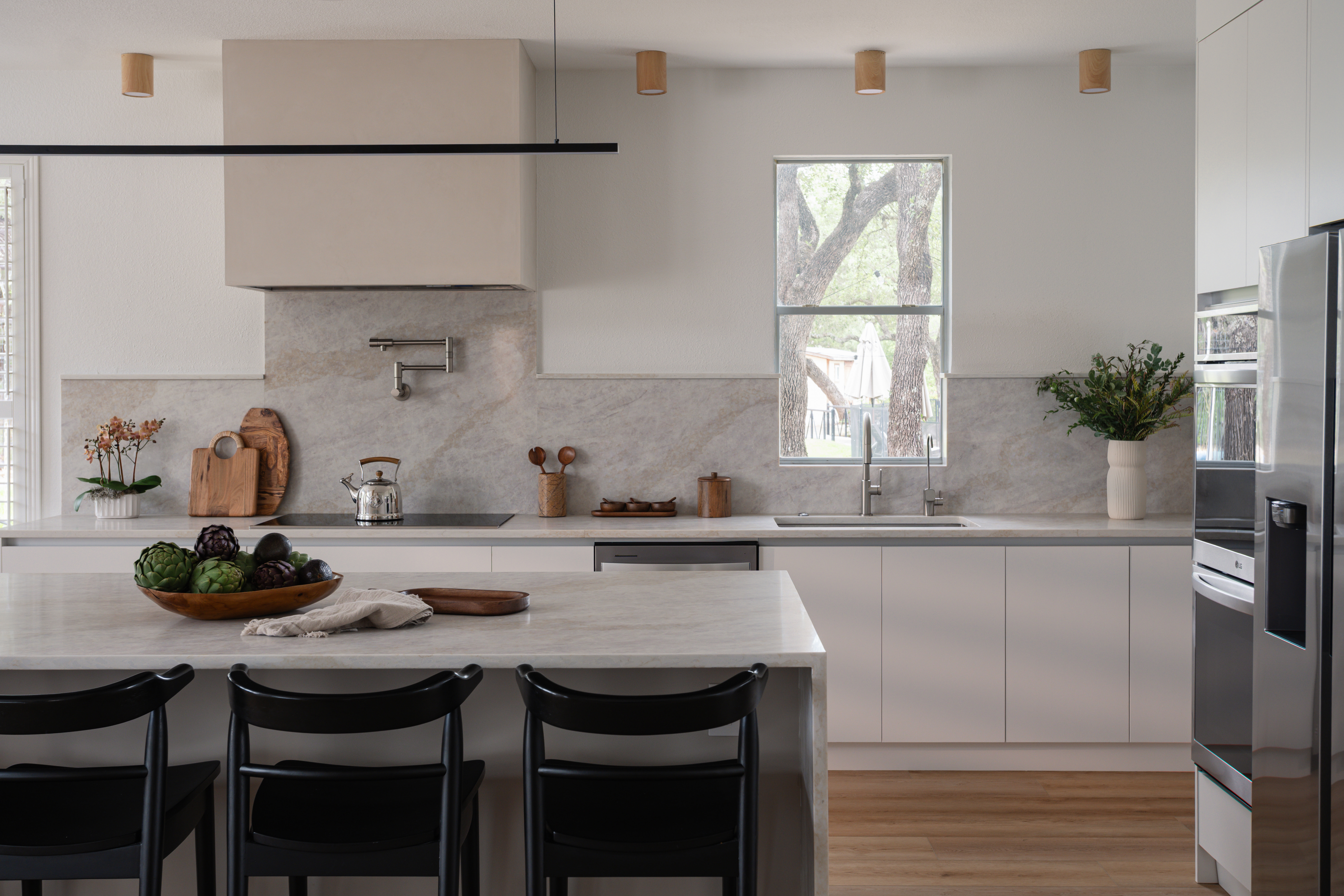 Kitchen island and range under a leafy window