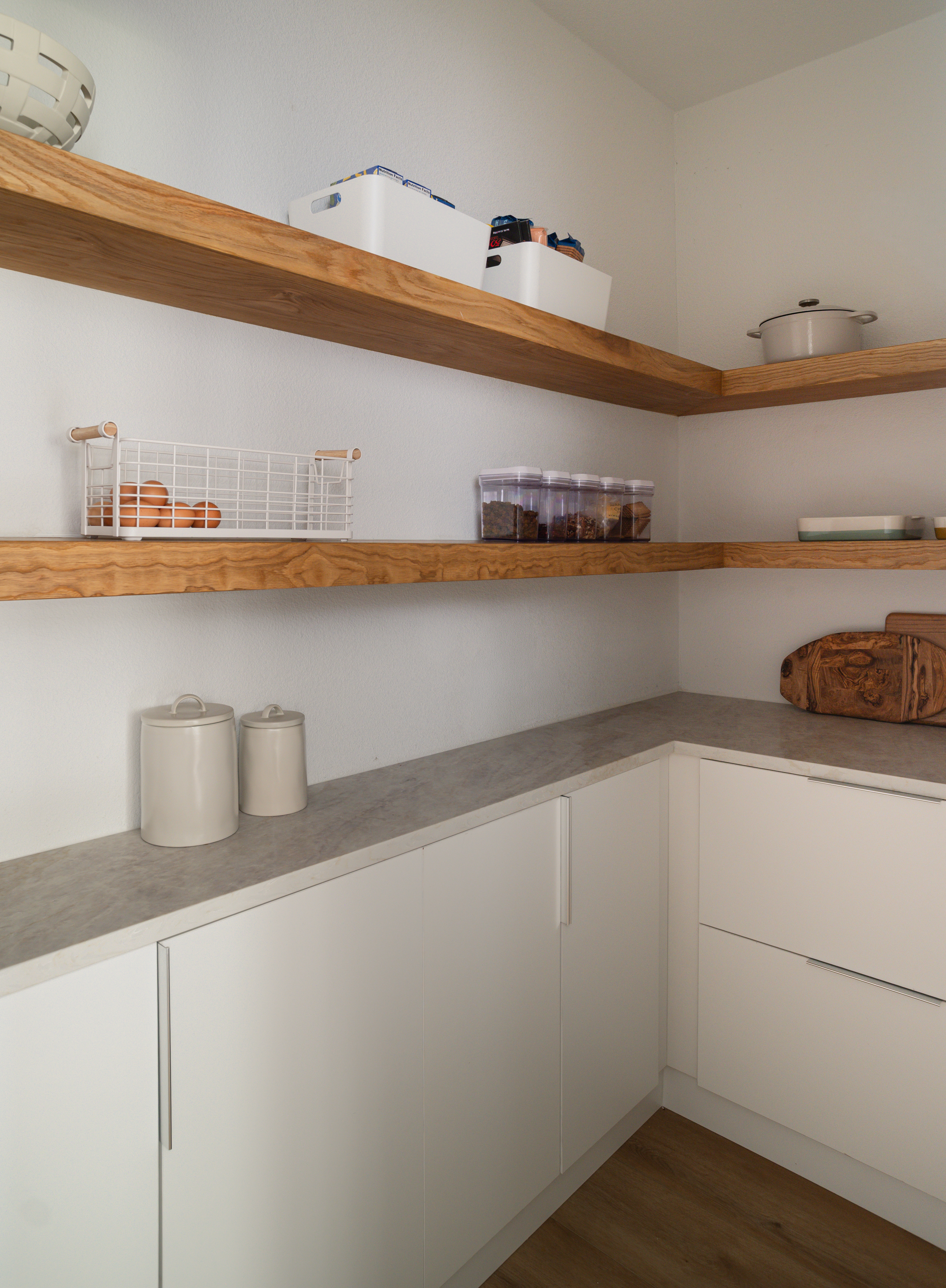 Pantry with floating oak shelves and concrete counter