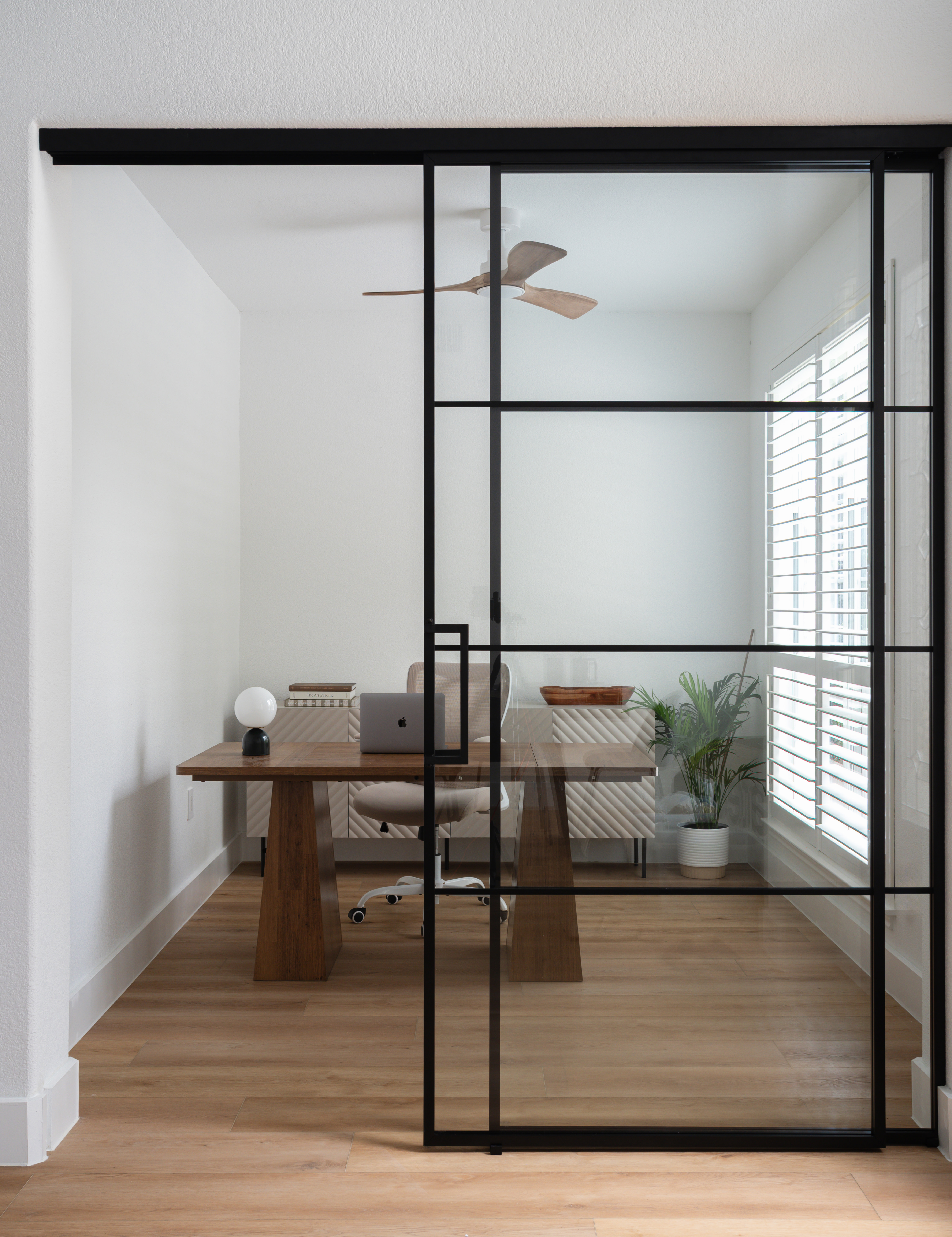 Home office behind black steel and glass door