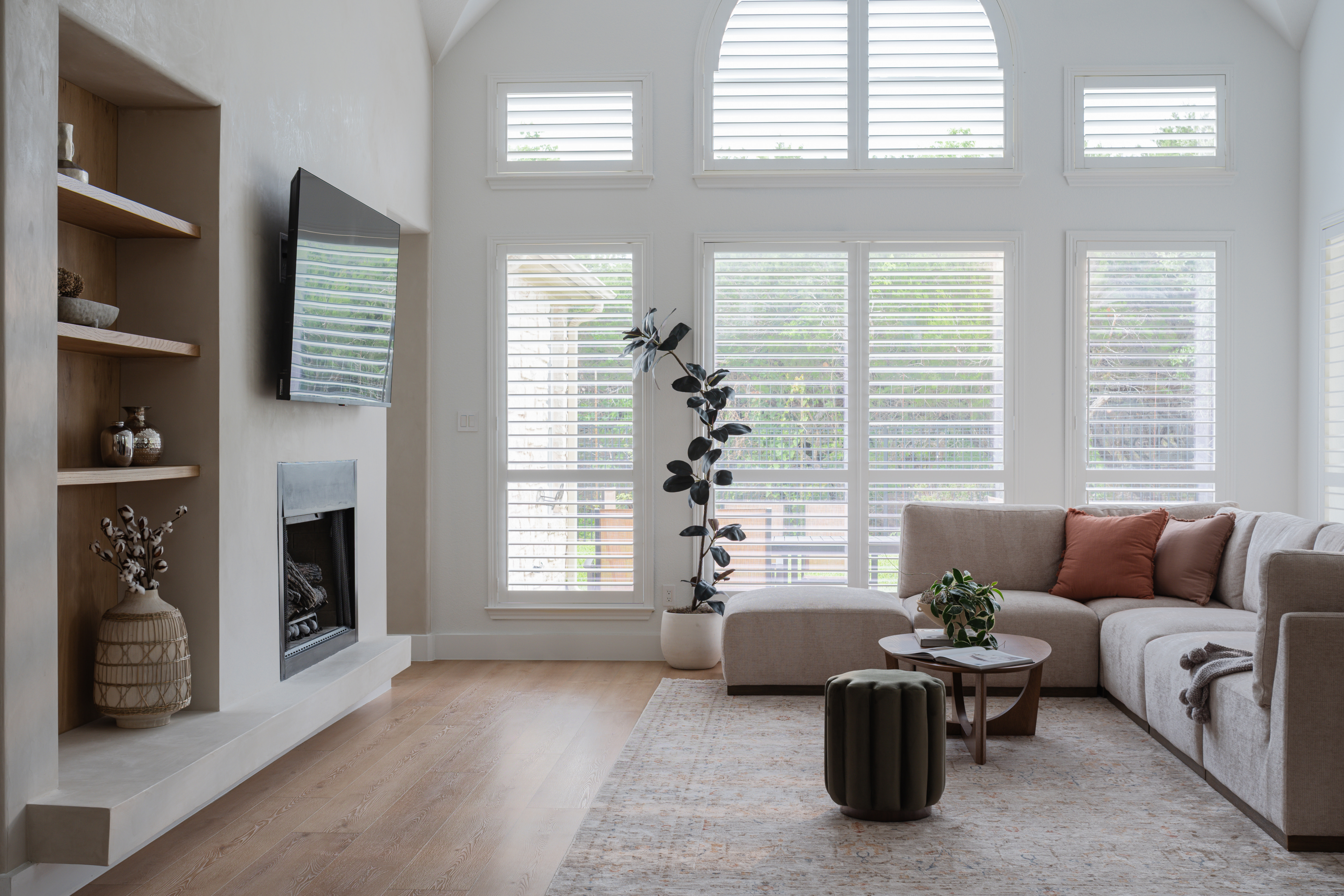 Living room with sectional, fireplace, and arched windows