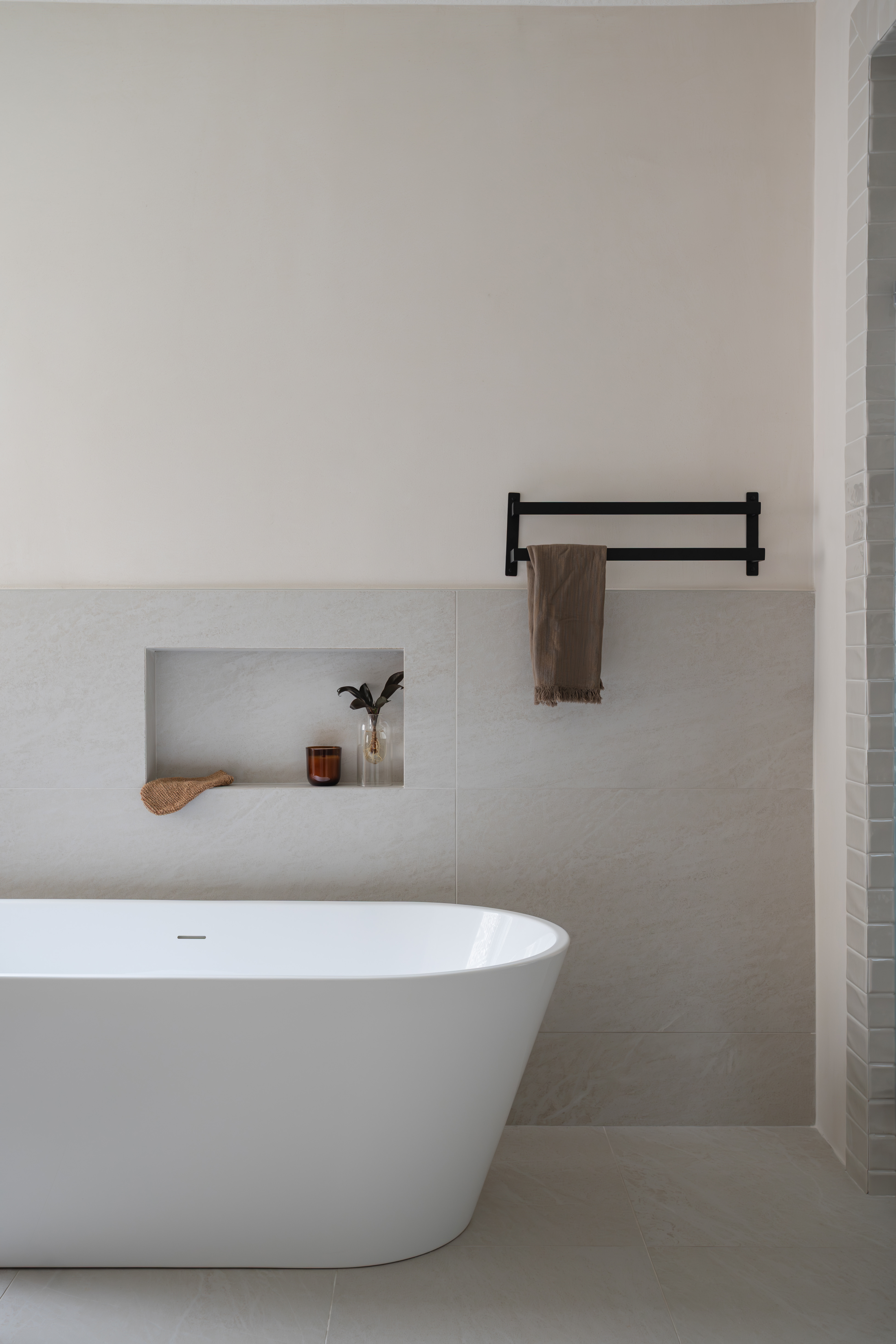 Freestanding tub with tiled niche and towel bar