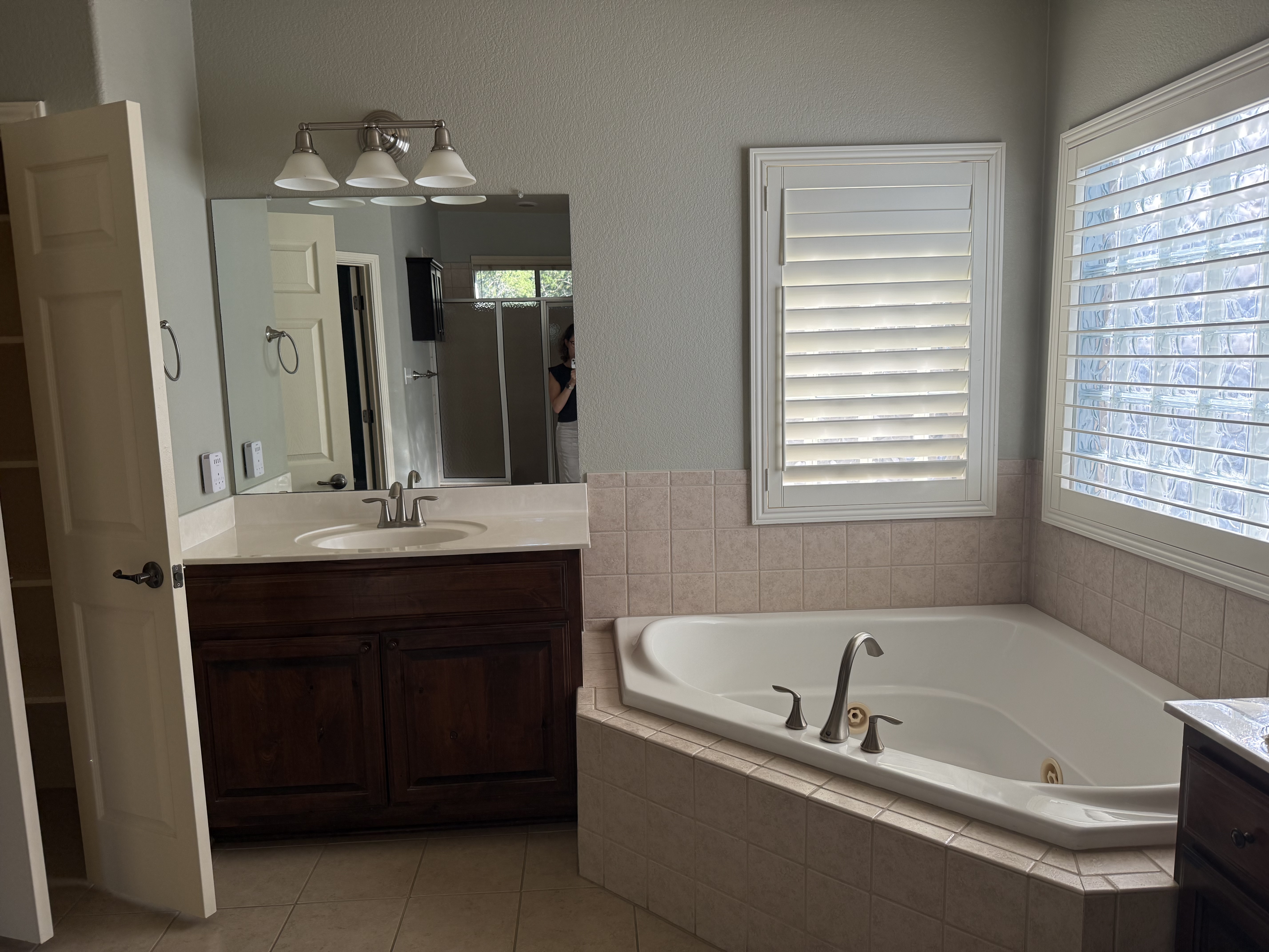 Dated bathroom vanity and tub before the remodel