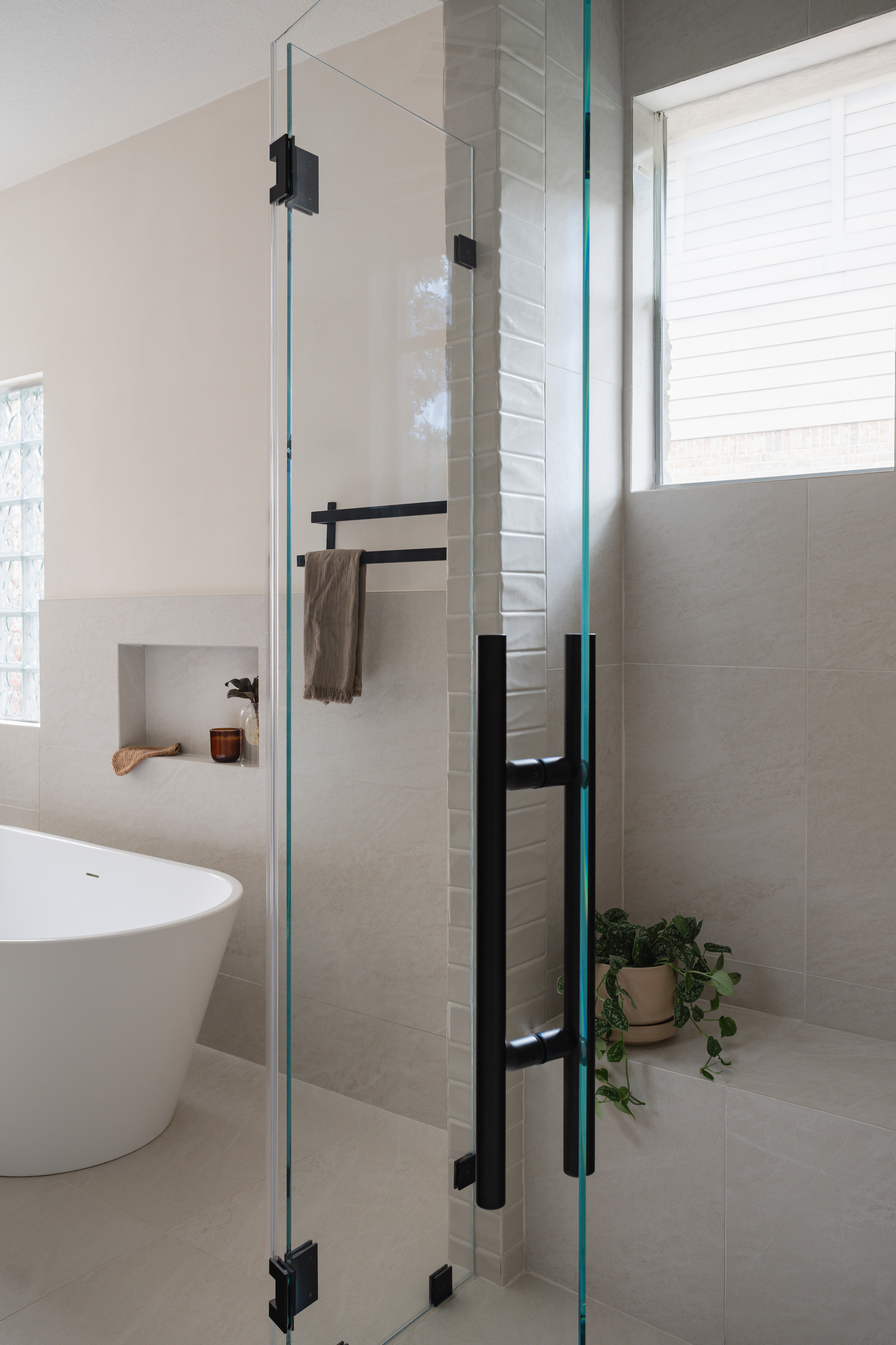 Glass shower door detail with black hardware