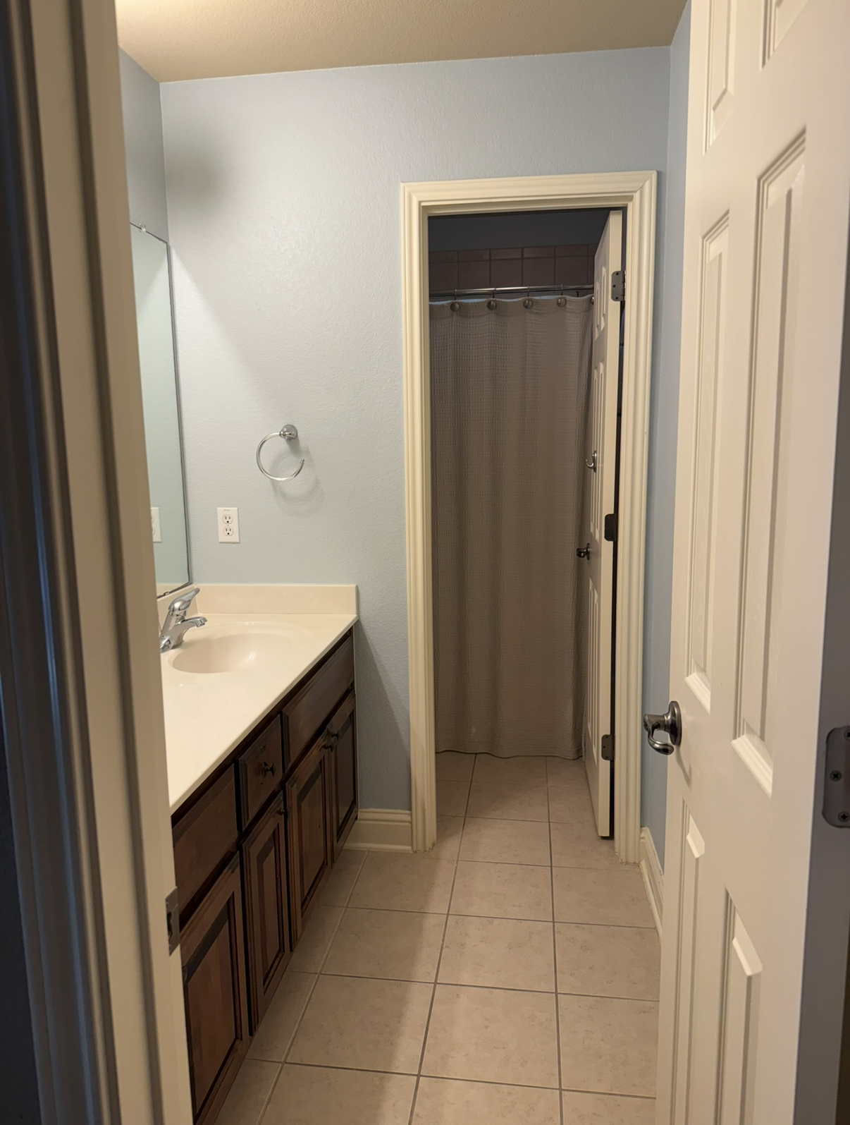 Dated bathroom with blue walls and dark vanity before the remodel